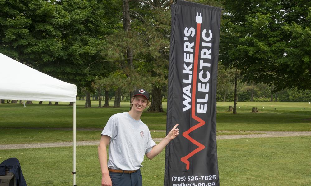 Person pointing at a sponsorship sign