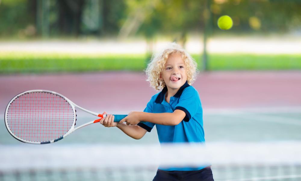 Little boy playing tennis