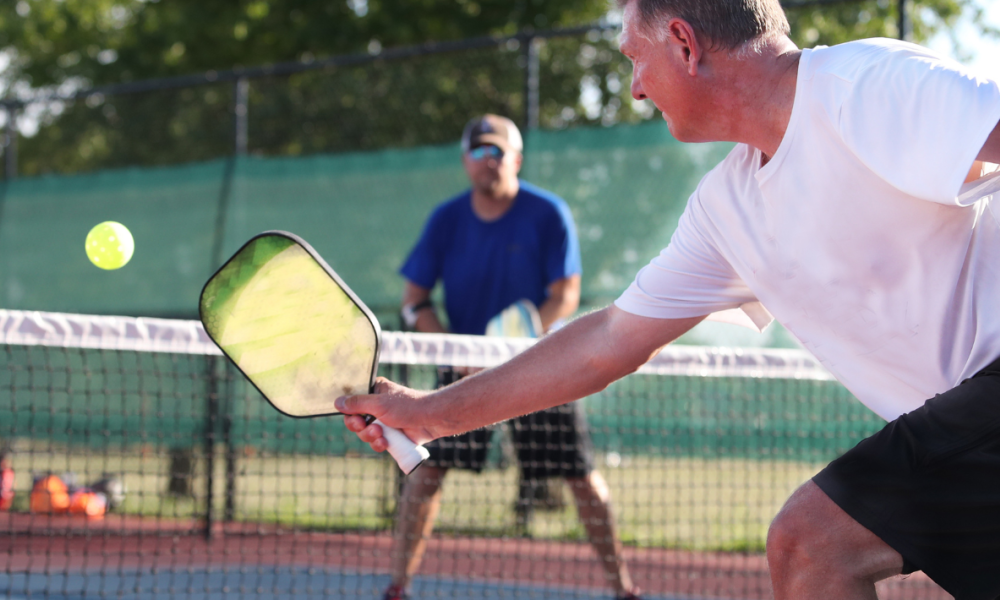 Three people playing pickleball.
