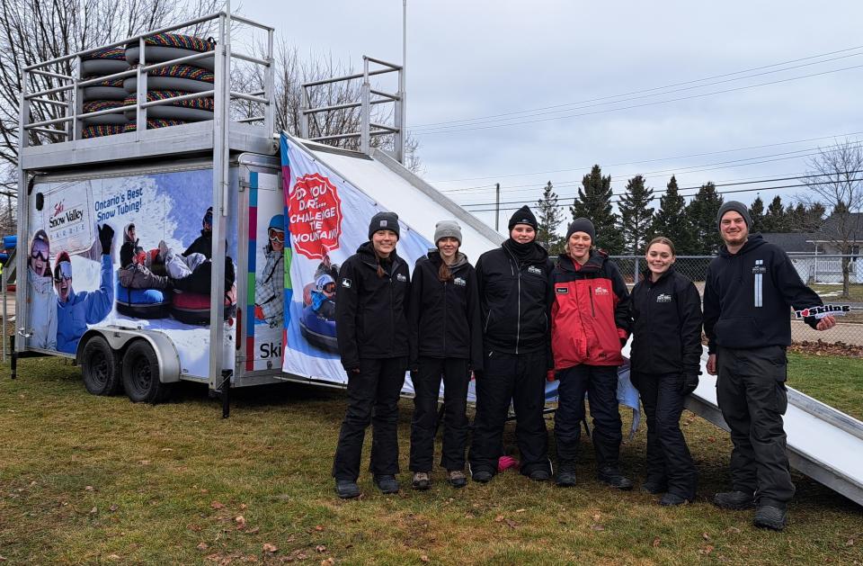 Snow Valley staff posing in front of the mobile tubing slide