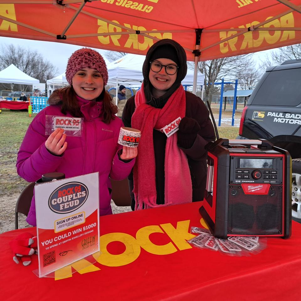 Rock 95 staff posing with swag at the Rock 95 radio booth