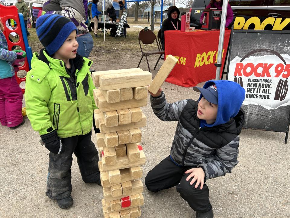 Two young boys starting a game of Jenga in front of the Rock 95 radio booth