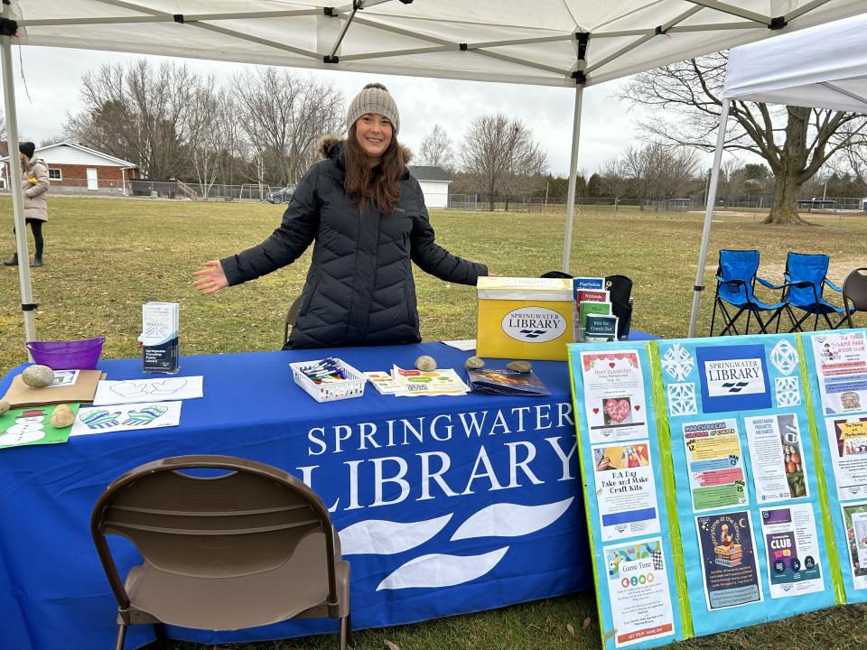 Staff from the Springwater Public Library showcasing their colourful booth of activities