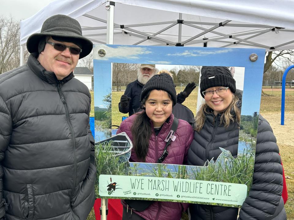 Family posing with the Wye Marsh photo frame and smiling