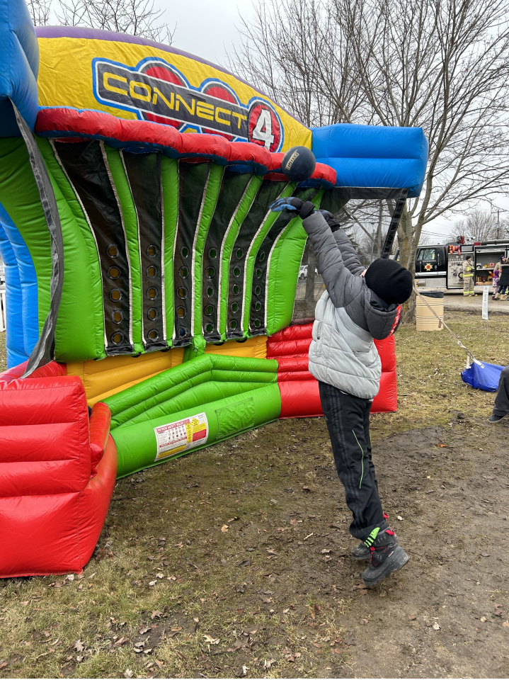 Youth jumping to throw the ball into the inflatable Connect 4 carnival game