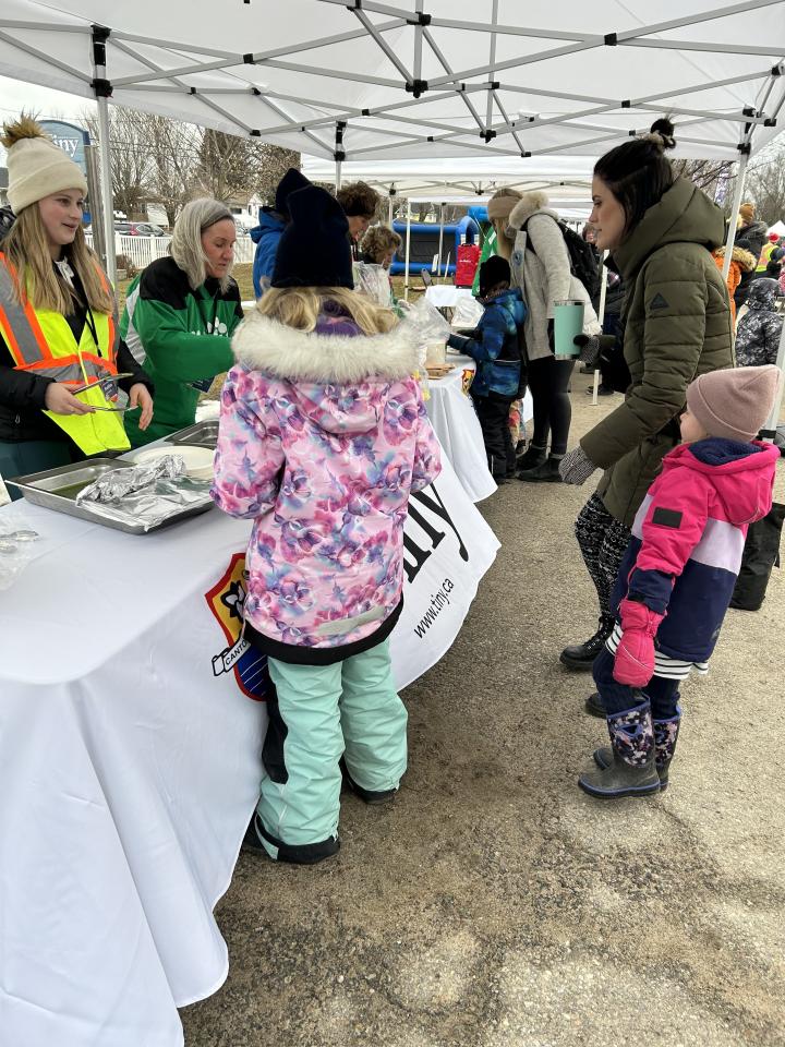 several people in line to get their pancake lunch with volunteers in the background