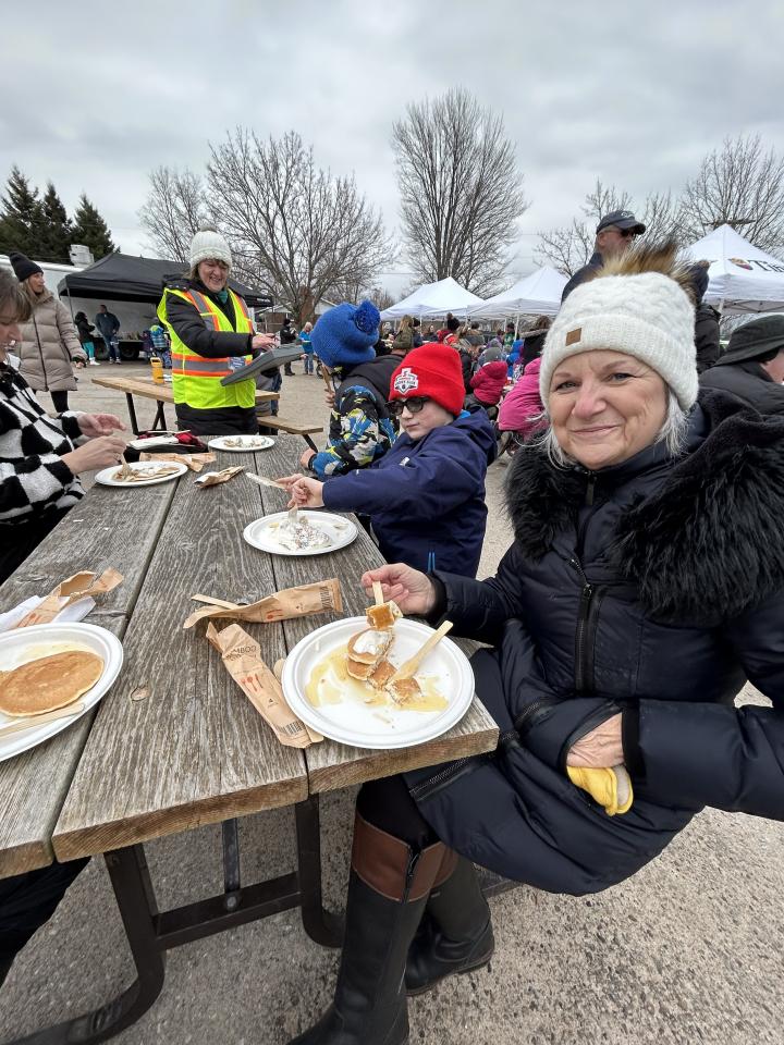 Family enjoying their pancakes at a picnic table 