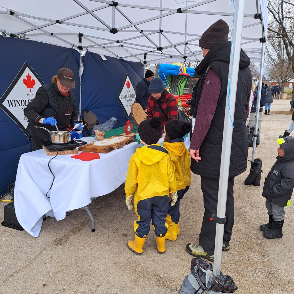 Young family visiting the Windlee Farms booth for a maple syrup treat