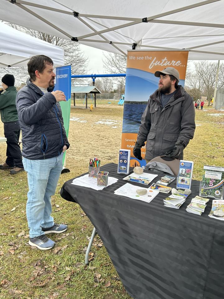 man talking to staff/volunteer at the Severn Sound Environmental Association booth