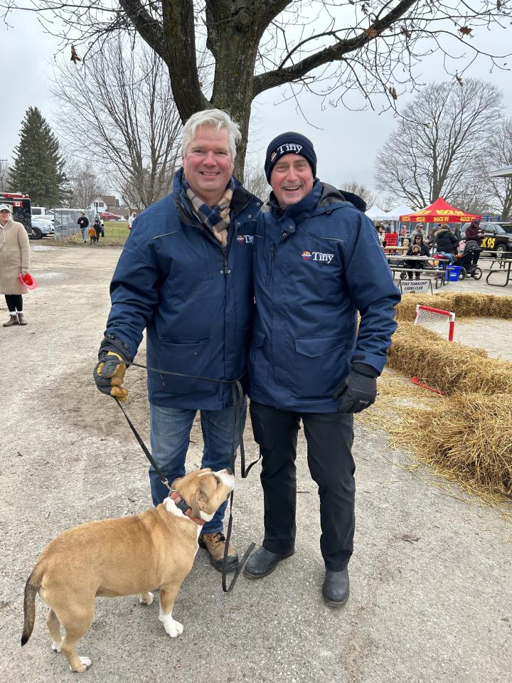 Mayor Evans and Deputy Mayor Miskimins with a light brown and white dog, Marley 