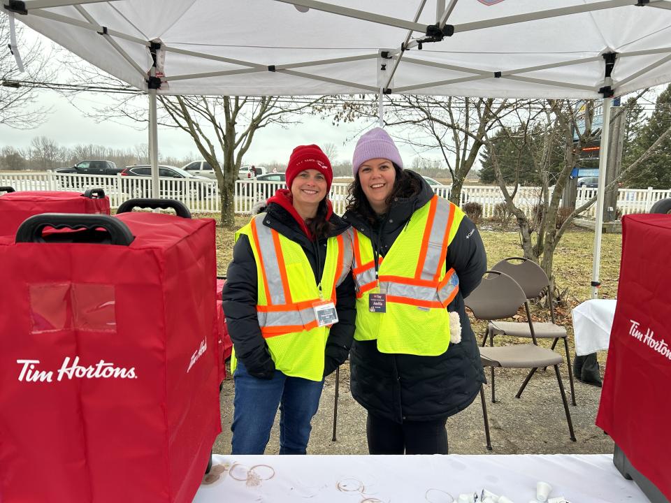 image of two volunteers at the hot drink station with Tim Hortons branded carafes in the foreground 