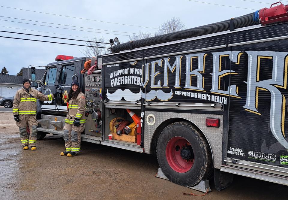 Two Tiny Firefighters standing in front of the branded Movember fire truck