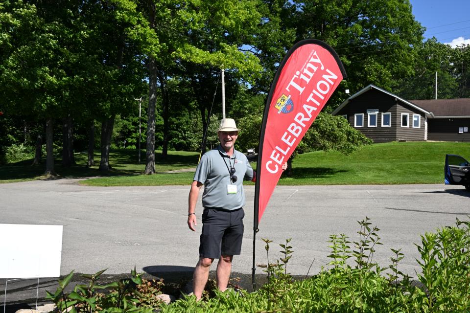 Deputy Mayor Miskimins standing next to the Tiny Celebration flag sign