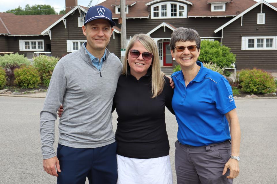 Golf tournament participants in front of the clubhouse