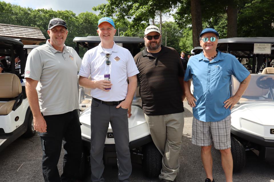 Men's golf foursome in front of their carts