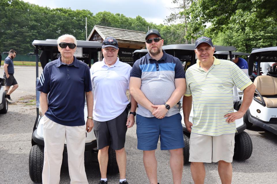 Men's golf foursome in front of their carts