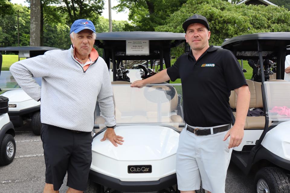 Men's pair in front of their golf cart