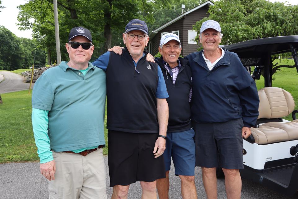 Men's golf foursome in front of their carts