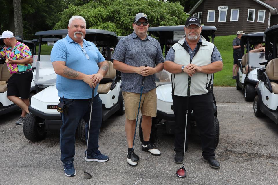 Three male golfer posing with their clubs in the morning of the tournament