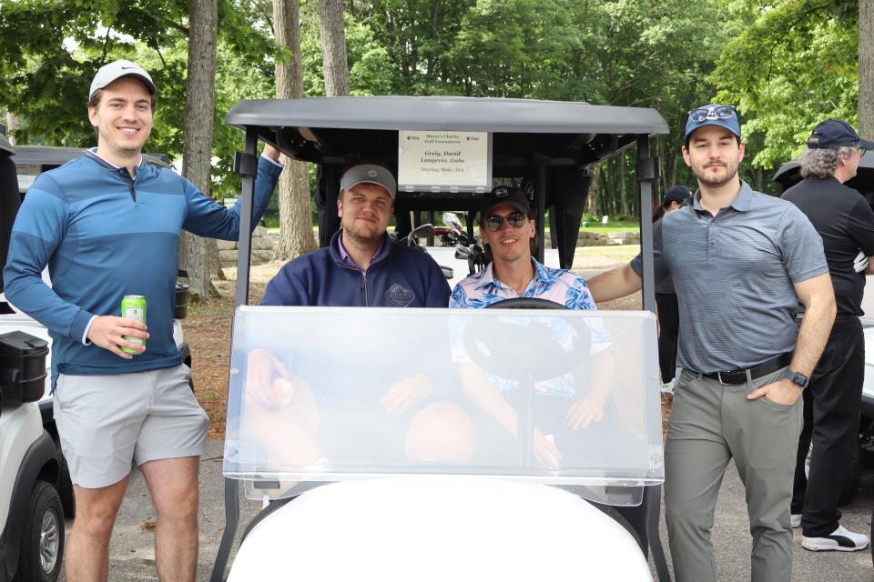 Men's foursome - two men sitting inside the cart and one on either side standing