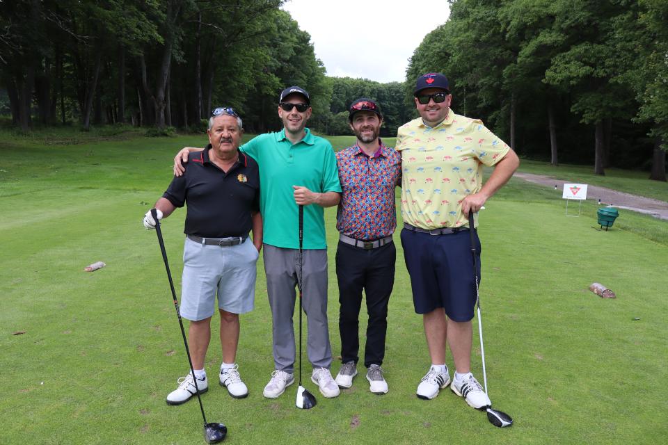 Men's golf foursome in on the greens at the longest drive contest hole 