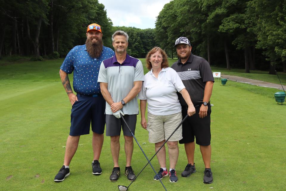 Mixed golf foursome on the greens at the longest drive contest hole 