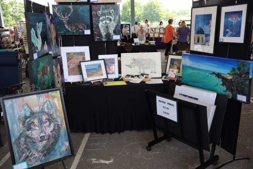 Image of a booth of paintings for sale at the vendor fair