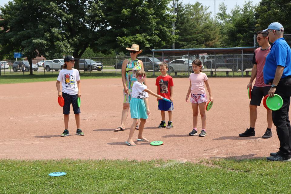 Image of a family and friends playing disc golf