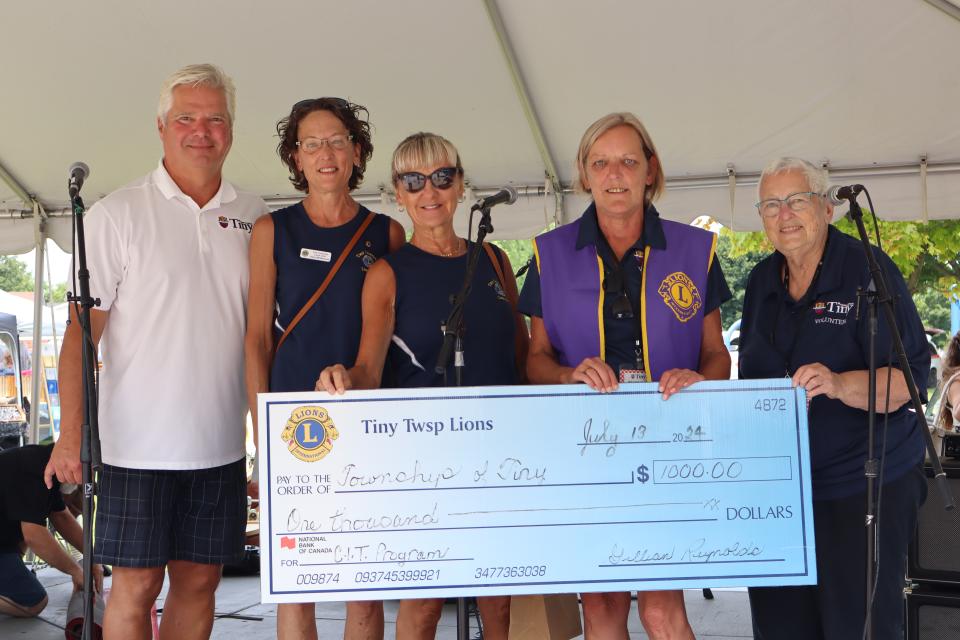 Mayor Evans posing with representatives from the Tiny Township Lions Club and a large cheque