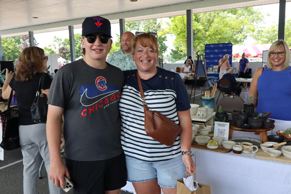 Mom and son smiling after picking up some pottery at the vendor fair