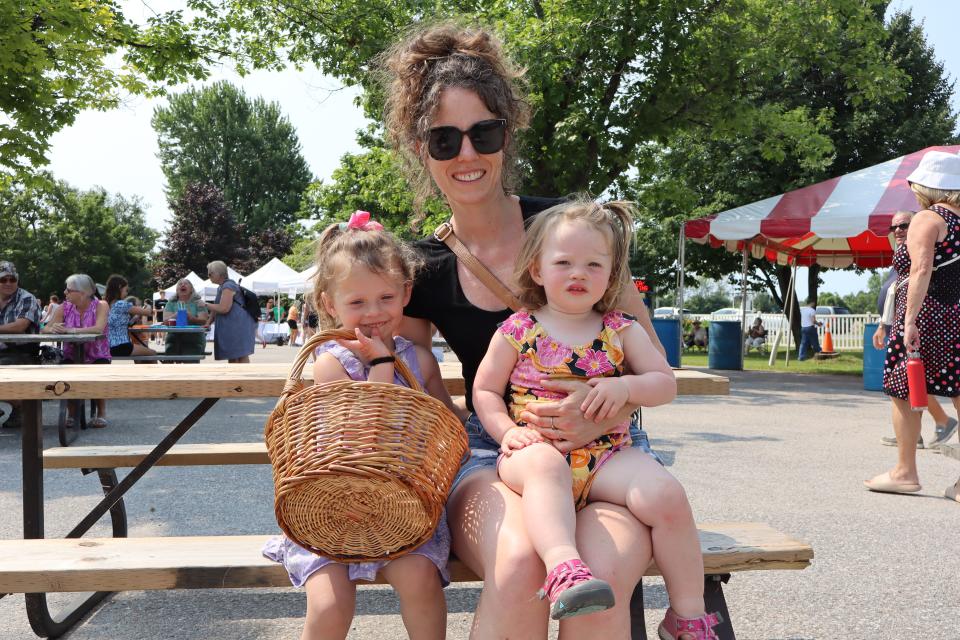 Mom with two young daughters sitting on a picnic table