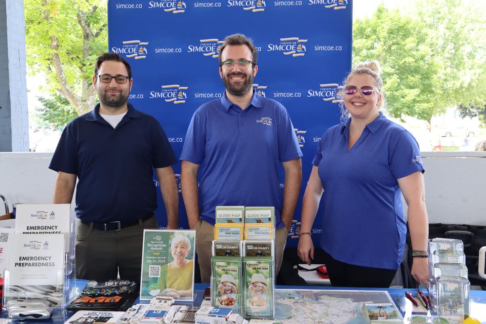 Three County of Simcoe staff with experience simcoe and emergency management information on the table