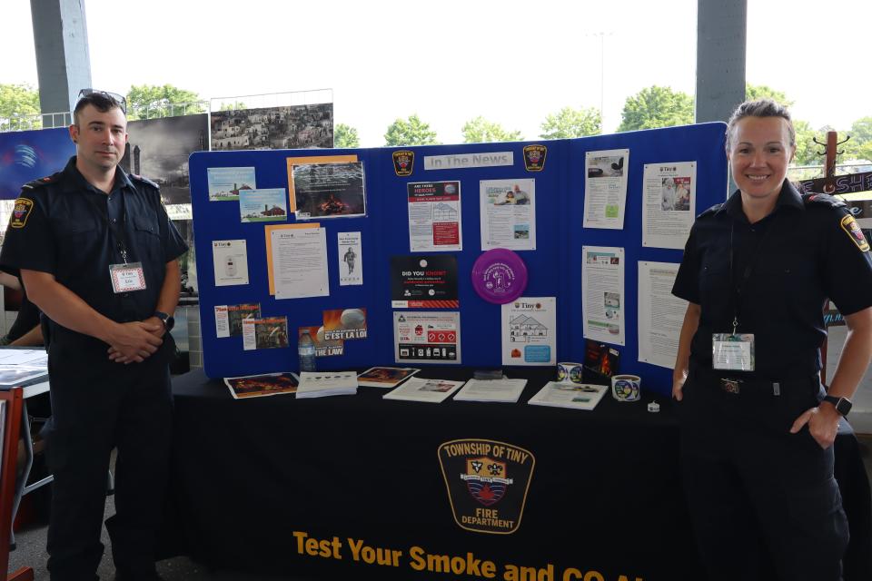 Township of Tiny firefighters standing at their information booth