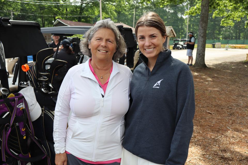 Two golfers standing next to the row of golf carts before the tournament starts