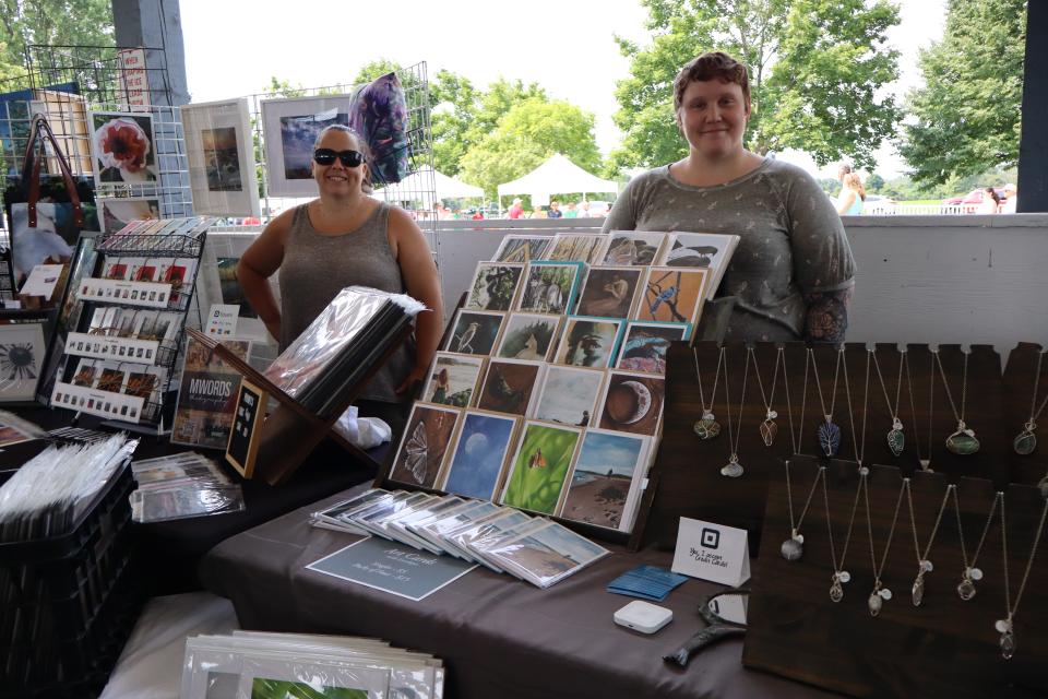 Two women standing behind their vendor booth