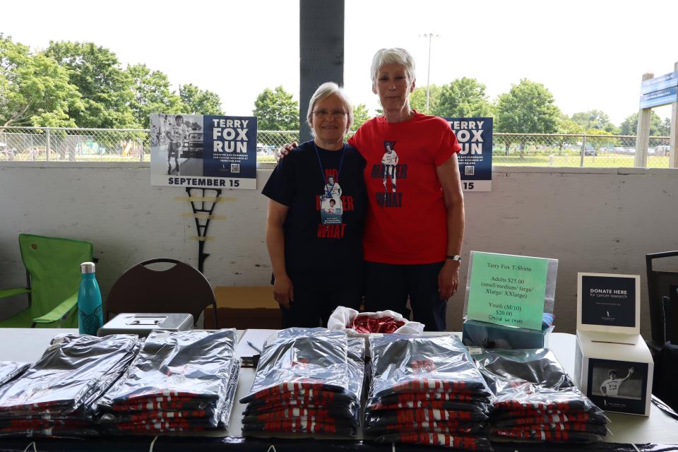 Two women standing side by side at the Terry Fox Run table