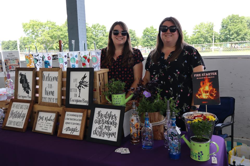 Two young women standing behind their table in the vendor fair