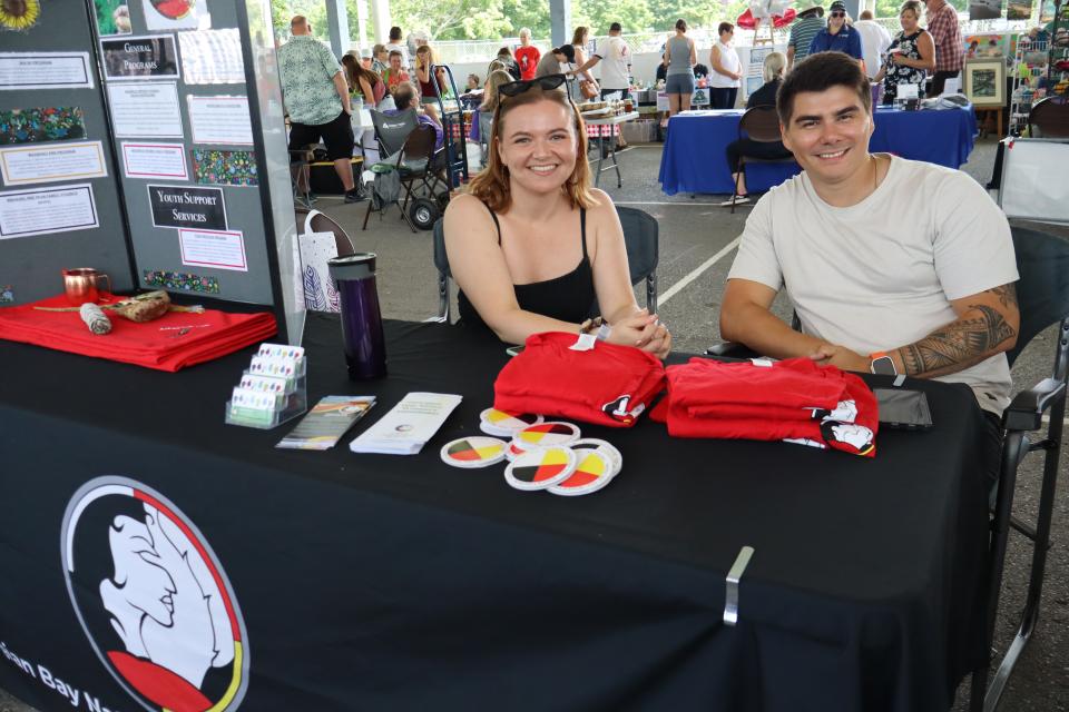 Woman and man sitting behind the Georgian Bay Native Friendship Centre table