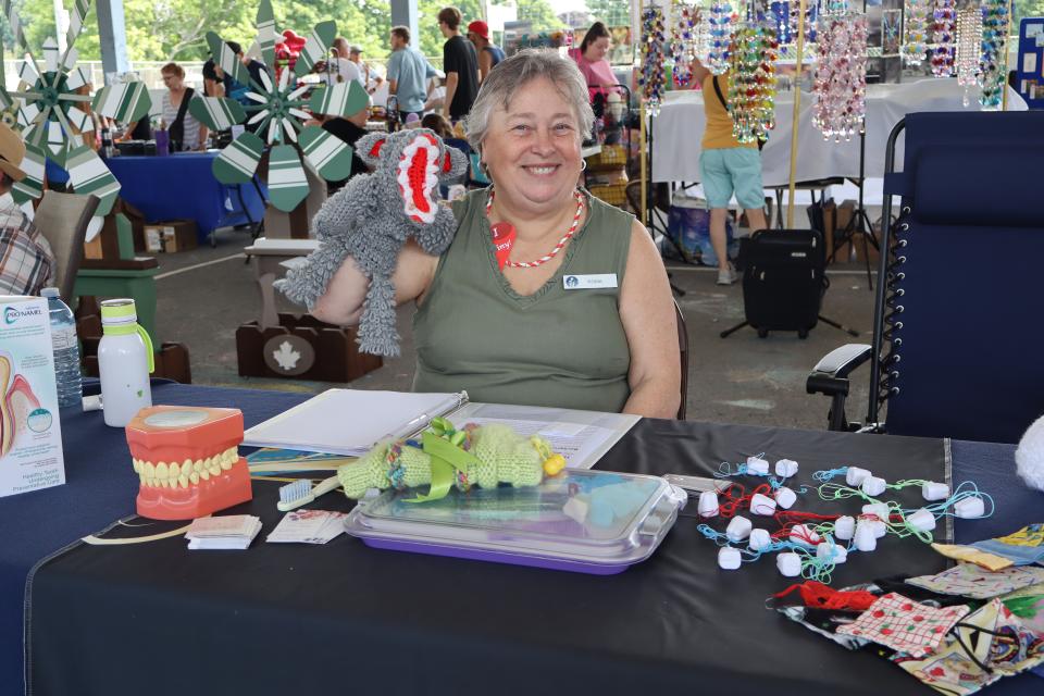 Woman showing off their handmade designs at the vendor fair