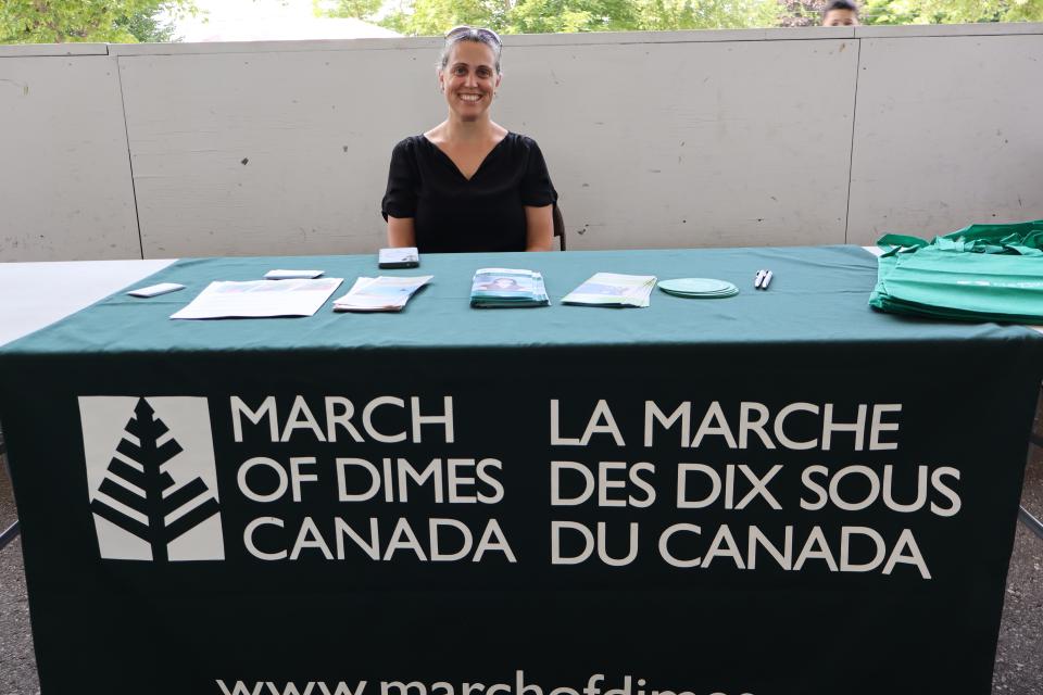 Woman sitting behind the March of Dimes Canada table