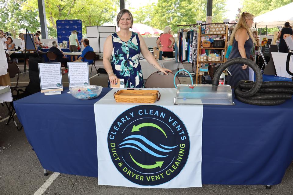 Woman standing behind their Clearly Clean Vents booth