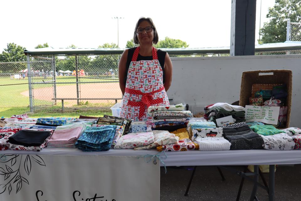 Woman standing behind their clothing booth