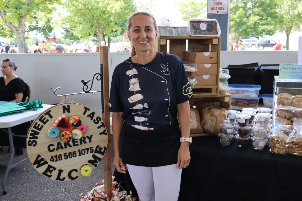 Woman standing in their Sweet N Tasty Cakery Booth