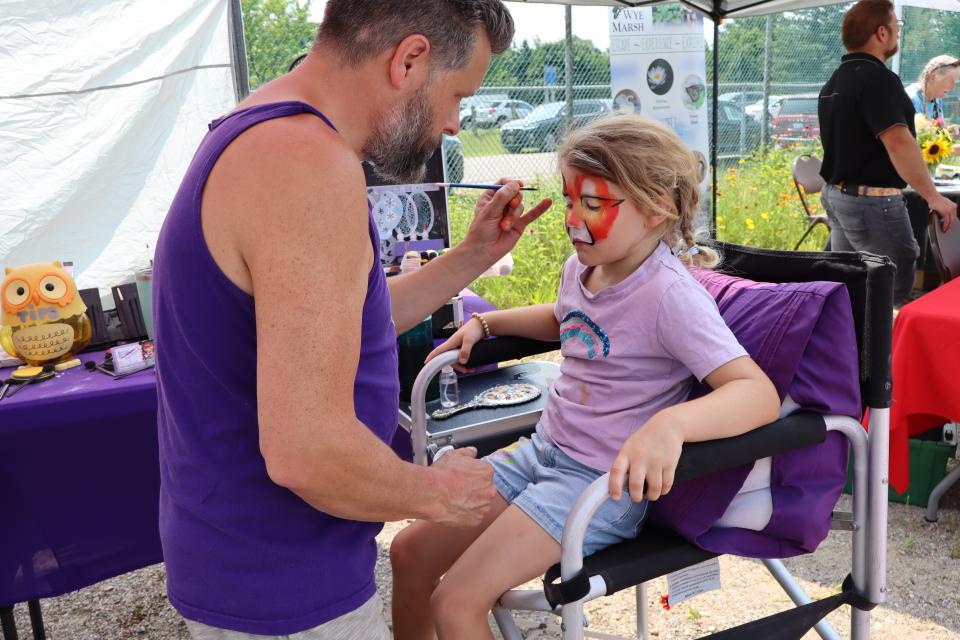 Young girl getting their face painted