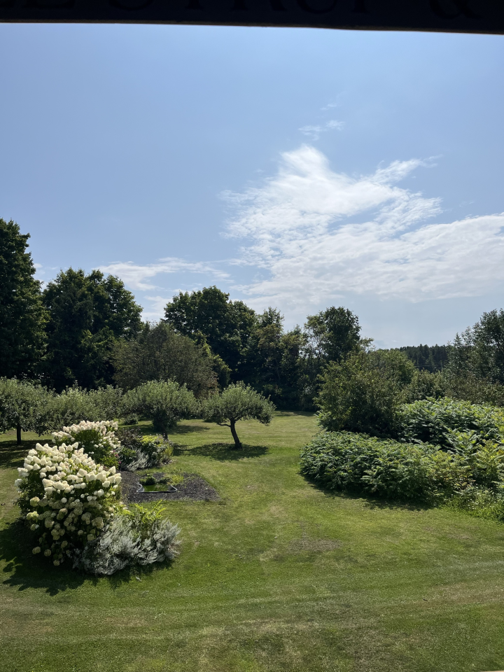 view of the farm grounds with flowering bushes and trees