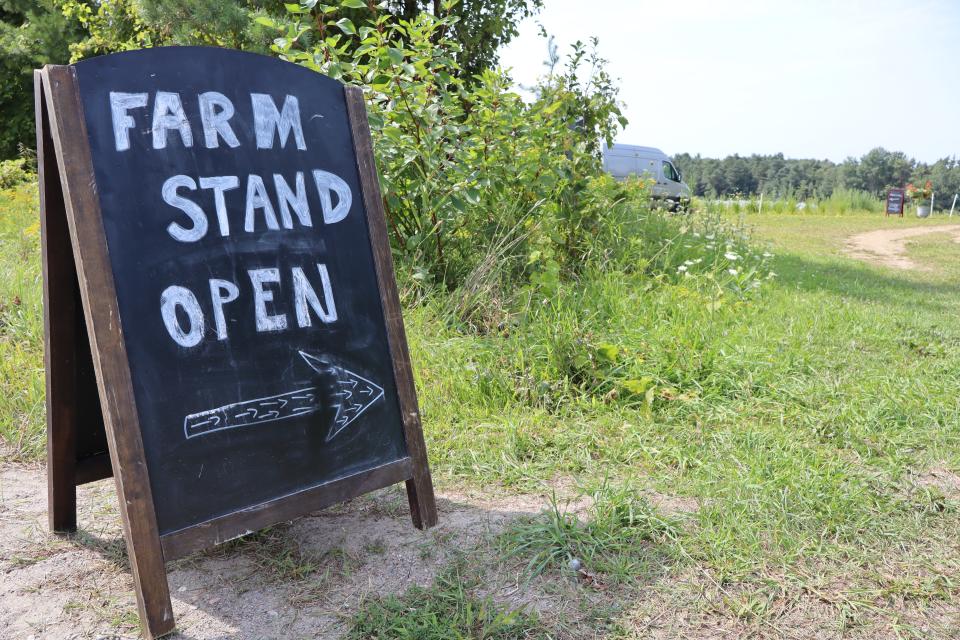 image of an a-frame sign that reads farm stand open with an arrow pointing toward the driveway