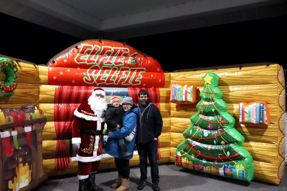 young family posing with santa in the elfie selfie inflatable station