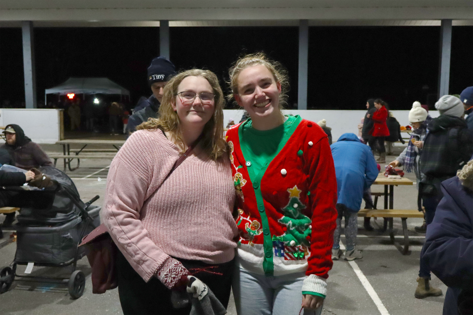 two young women posing for a photo side by side under the Perkinsfield Pavilion