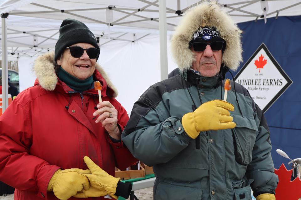 couple enjoying freshly made maple taffy