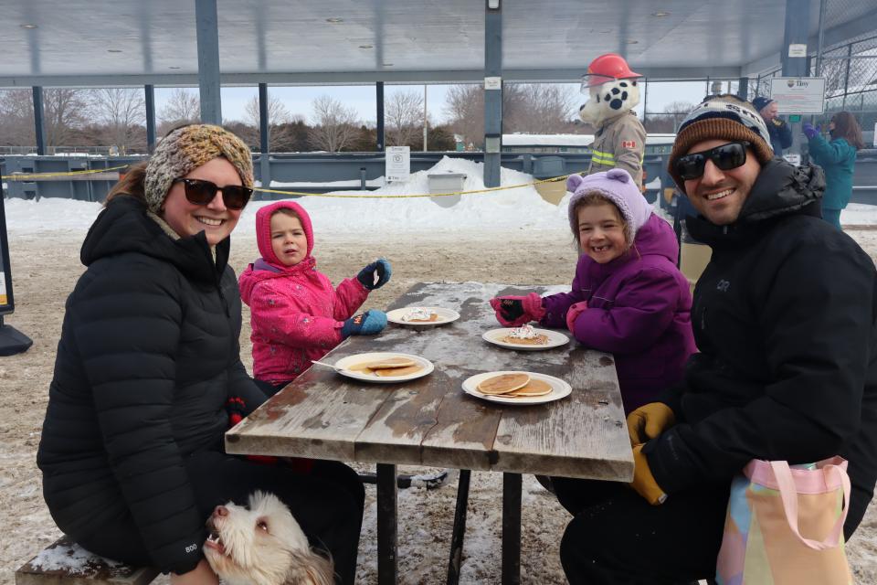 family with two children and their dog enjoying a free pancake lunch